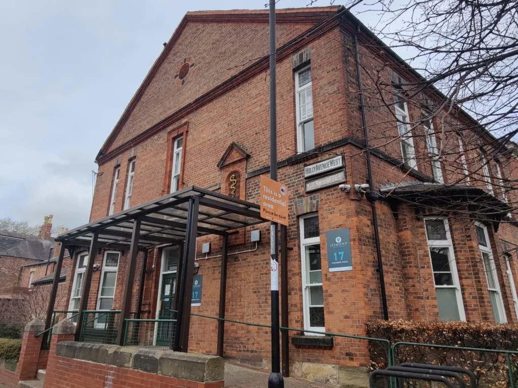 Historic brick building with modern entrance and signage in Jesmond.