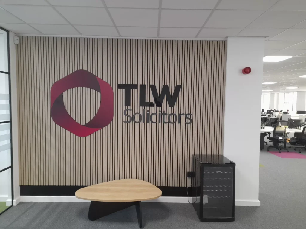 Modern office interior with TLW Solicitors logo on wall.