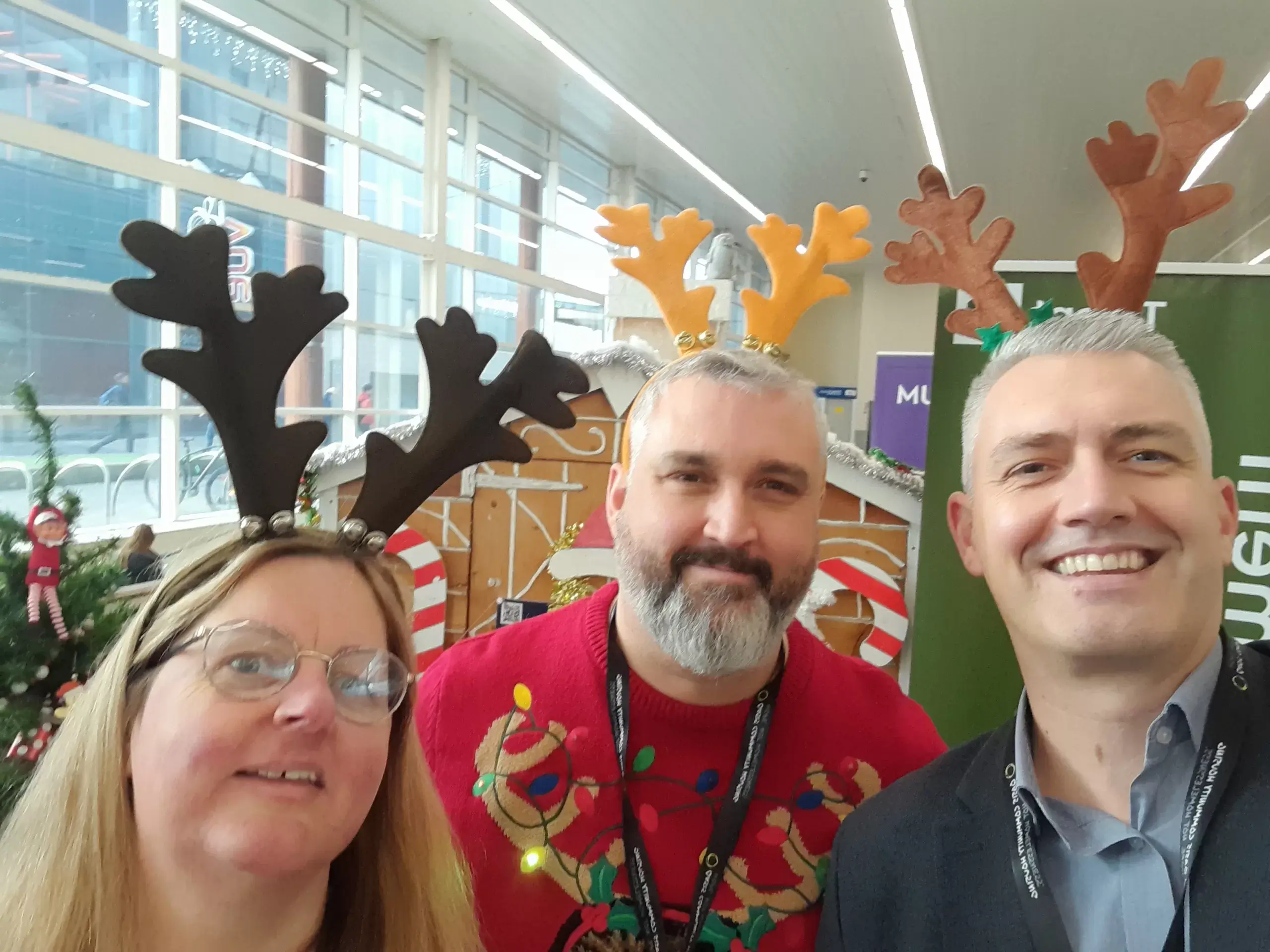 Employees wearing reindeer antlers at Christmas office event.