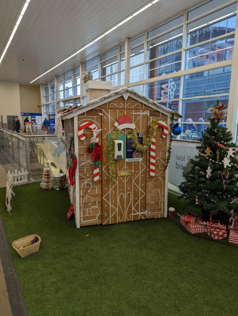 Decorative gingerbread house with Christmas decorations at a shopping centre.