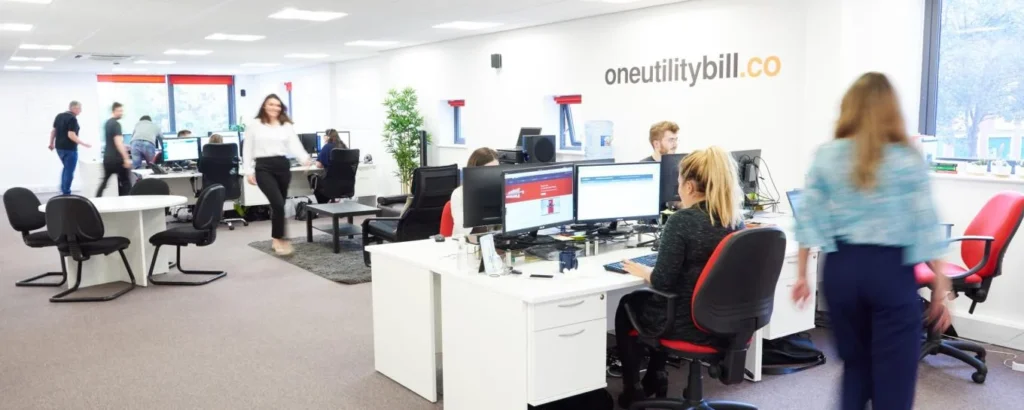 Modern office with employees working at desks and computers.