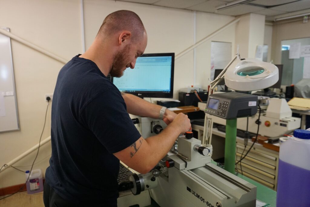 Skilled technician working with precision machinery in a modern workshop.