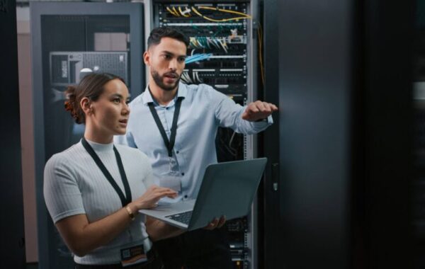 IT professionals working together in a data centre with servers and networking equipment.